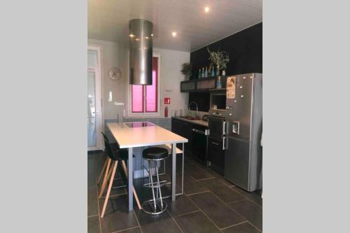 une cuisine avec un réfrigérateur et une table à l'intérieur dans l'établissement T4 spacieux dans quartier le plus animé de Perpignan idéal pour visa pour l’image, à Perpignan