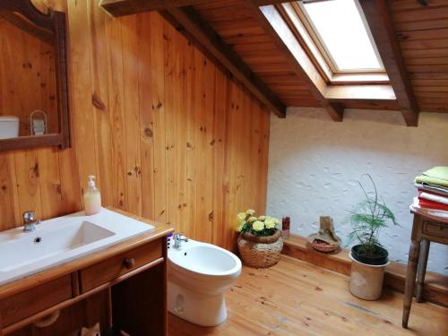 a bathroom with a toilet and a sink and a skylight at Casas Altas Obidos - AL in Sobral