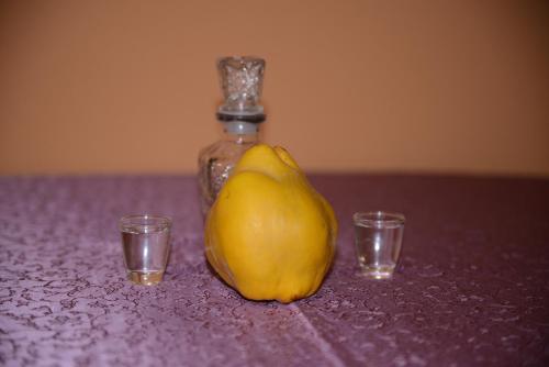 a yellow pear sitting next to two glasses at Brvnare Dunja 1 i Dunja 2 in Kraljevo