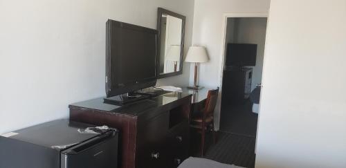 a hotel room with a television on a dresser at Niagara Falls Courtside Inn in Niagara Falls