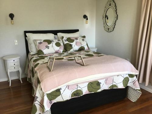 a bedroom with a bed with a pink blanket and pillows at THE AMBERS in Thames