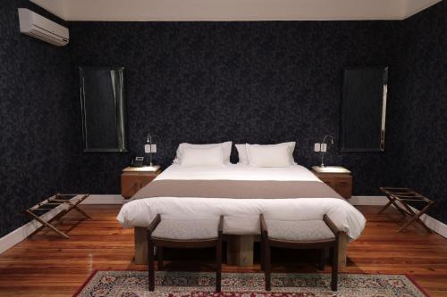 a bedroom with a large bed with two chairs at Finca Adalgisa in Chacras de Coria