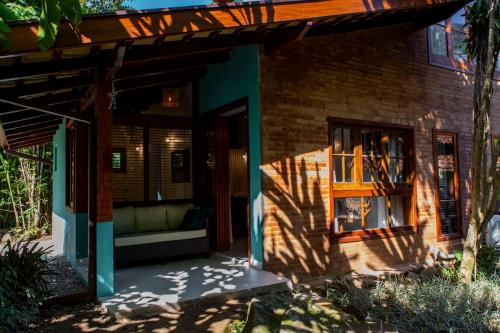 a house with a porch with a couch in front of it at Casa Ka in Maresias