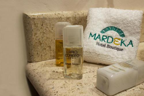 a bathroom counter with a bottle of alcohol and a towel at Hotel Boutique Mardeka in Orizaba