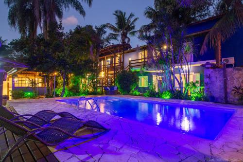 a swimming pool in front of a house at night at Estrela do Mar Paraty in Paraty