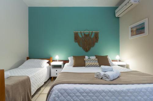 two beds in a bedroom with blue walls at Estrela do Mar Paraty in Paraty