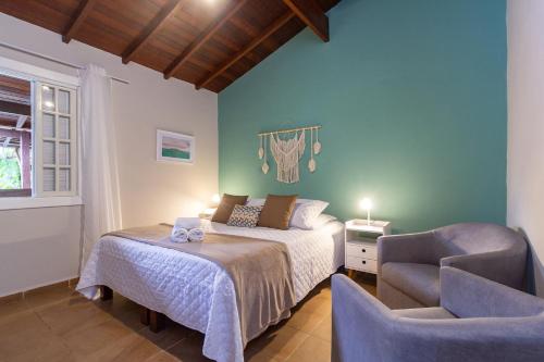 1 dormitorio con 1 cama y 1 silla en Estrela do Mar Paraty, en Paraty