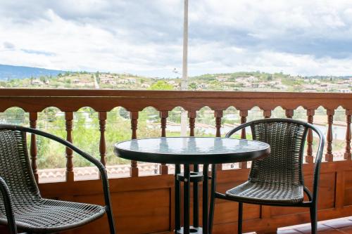 a table and chairs on a balcony with a view at Hotel El Giro in Villa de Leyva