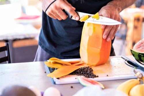 a person is holding a bag of fruit on a table at La Ventana Hostel in La Ventana