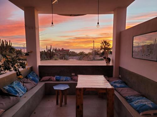 a porch with a table and a view of the beach at La Ventana Hostel in La Ventana