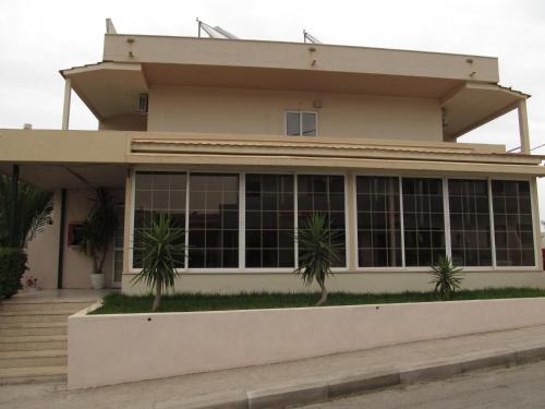 a house with palm trees in front of it at Saint Amon Hotel in Faliraki