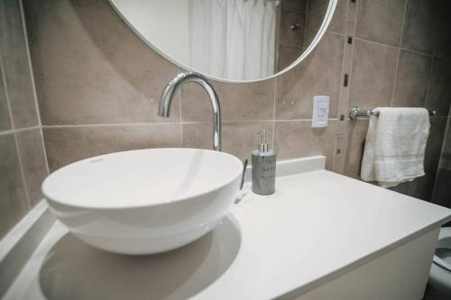 a bathroom with a bowl sink and a mirror at Recoleta White Home in Buenos Aires