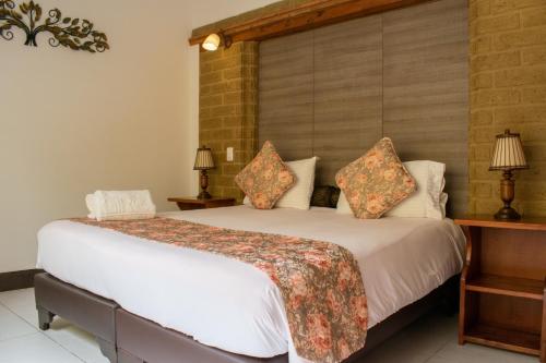 a bedroom with a large white bed with pillows at Hotel El Giro in Villa de Leyva