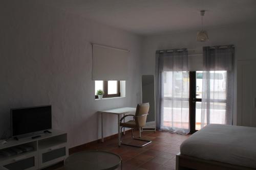 a bedroom with a bed and a desk and a television at Casa Volcan De Gayria in Valles de Ortega