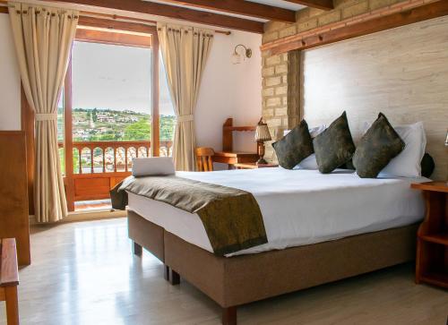 a bedroom with a large bed and a balcony at Hotel El Giro in Villa de Leyva
