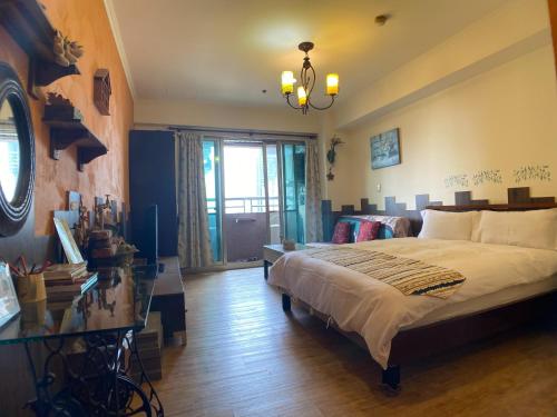 a bedroom with a large bed and a glass table at CT Theme Suite in Kaohsiung