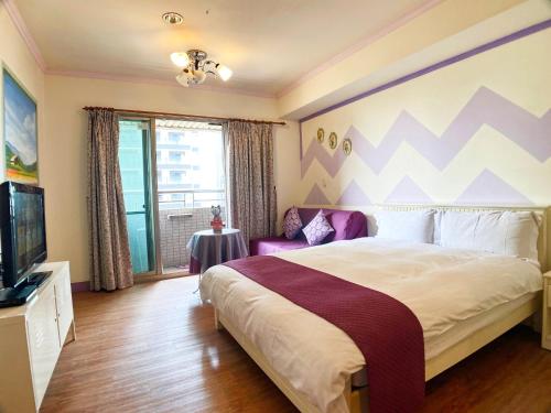 a bedroom with a large bed and a tv at CT Theme Suite in Kaohsiung