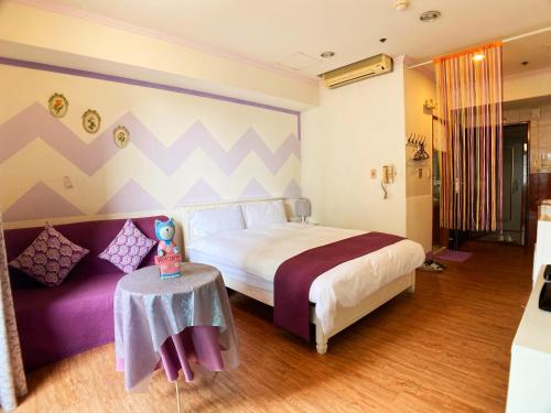 a bedroom with a large bed and a table at CT Theme Suite in Kaohsiung