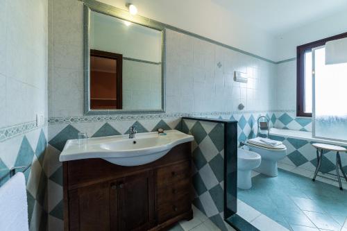 a bathroom with a sink and a toilet and a mirror at Bed And Breakfast Marina d'Aspra in Bagheria