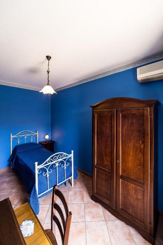 a blue bedroom with a bed and a wooden cabinet at Bed And Breakfast Marina d'Aspra in Bagheria