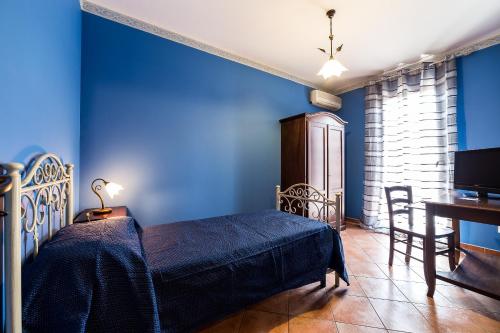 a bedroom with blue walls and a bed and a desk at Bed And Breakfast Marina d'Aspra in Bagheria