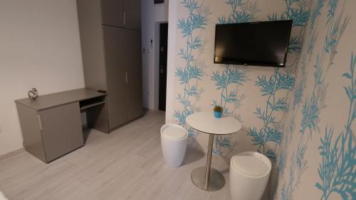 a room with a table and a tv on a wall at Anna Villa Füred Boutique Rooms in Balatonfüred