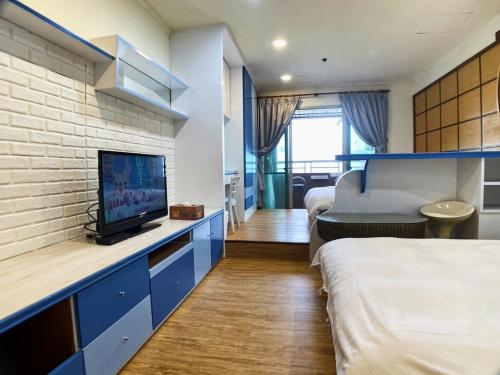 a hotel room with a bed and a tv at CT Theme Suite in Kaohsiung