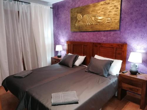 a bedroom with a large bed with purple walls at CASA MONTES in Playa Blanca