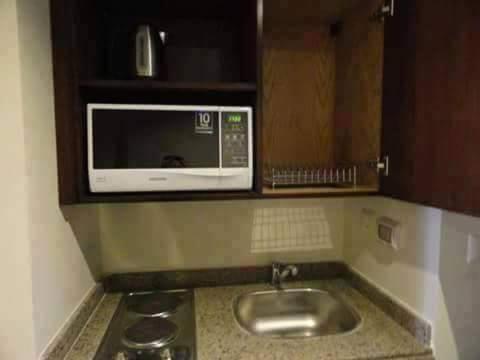 a microwave above a sink in a kitchen at Porto Sauth Beach Chalets Family,s only AN in Ain Sokhna