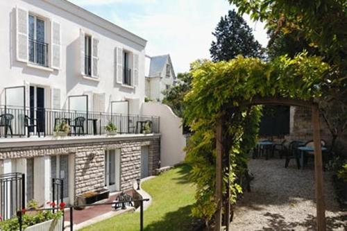 un arco frente a un edificio blanco en Hôtel Marie Louise, en Enghien-les-Bains