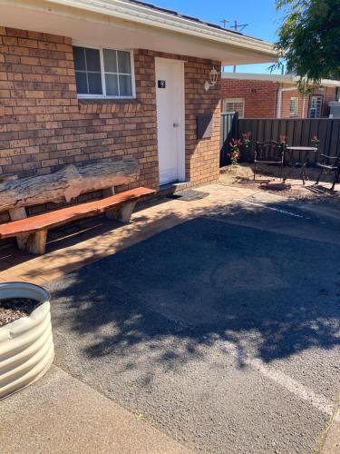 a brick house with a bench in front of it at Golden Grain Motor Inn in Tamworth