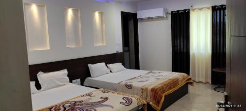 a hotel room with two beds and a television at Taj Castle A Boutique Homestay in Agra