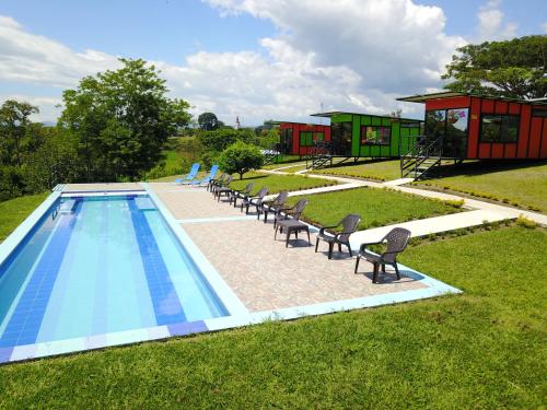 a swimming pool with chairs next to a house at Glamping - Calochorno in Alcalá