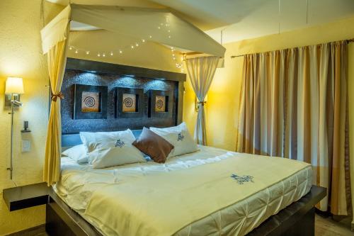 a bedroom with a large bed with a canopy at Hotel & Spa La Mansion del B Azul in Querétaro