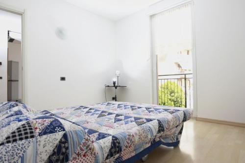 a bedroom with a bed with a quilt on it at Apartment Lake Maggiore - ITALIA in Maccagno con Pino e Veddasca