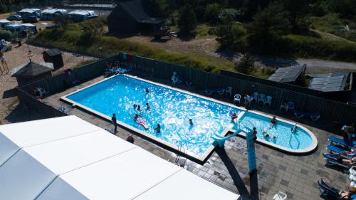 an overhead view of a swimming pool with people in it at First Camp Råbjerg Mile - Skagen in Skagen