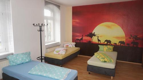 a room with two beds and a wall with a painting at Hostel Falkenstein in Falkenstein