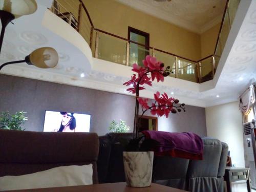 a living room with a couch and a vase with flowers at TeamVilla in Accra