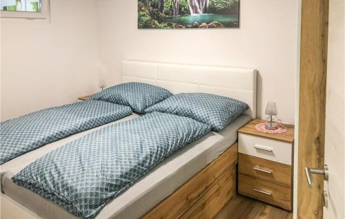 a bedroom with a bed with blue pillows and a night stand at Ferienwohnung - Waldviertel in Dorfstetten