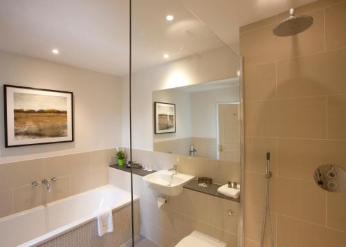 uma casa de banho com uma banheira, um lavatório e um chuveiro em The Bell Inn Hotel em Lyndhurst