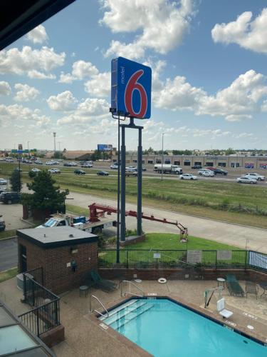 a view of a gas station with a sign and a pool at Motel 6 Oklahoma City OK Fairgrounds West in Oklahoma City