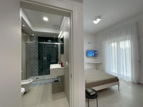 een slaapkamer met een bed en een badkamer met een douche bij Pianohome Sorrento in Piano di Sorrento
