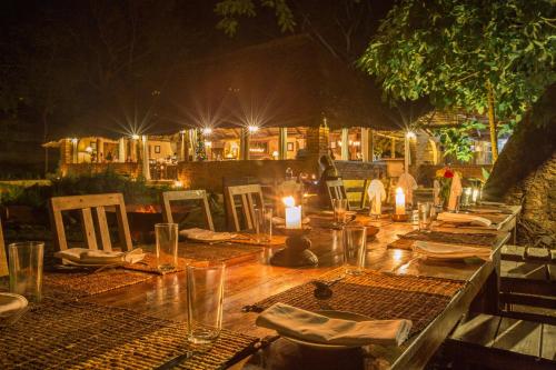 a wooden table with candles and plates on it at Rivertrees Country Inn in Usa River