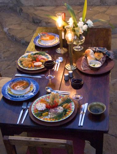 a table with plates of food and glasses of wine at Rivertrees Country Inn in Usa River