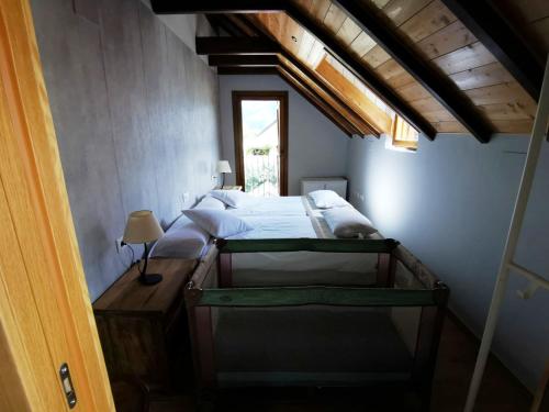 een slaapkamer met een bed en een raam in een kamer bij La Borda de Jaime in Piedrafita de Jaca