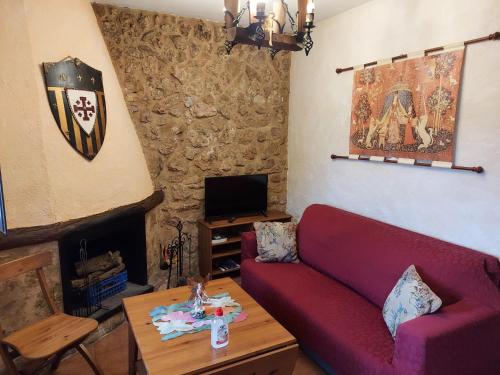 Una sala de estar con un sofá rojo y una mesa. en Torre Blanca, en Riópar Viejo