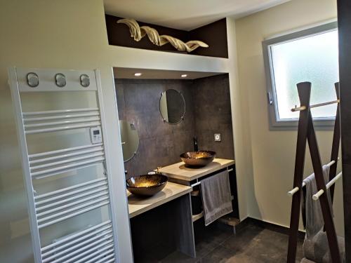 a bathroom with two sinks and two mirrors at La Cascatelle - Gîte entièrement climatisé in Savigny-en-Revermont