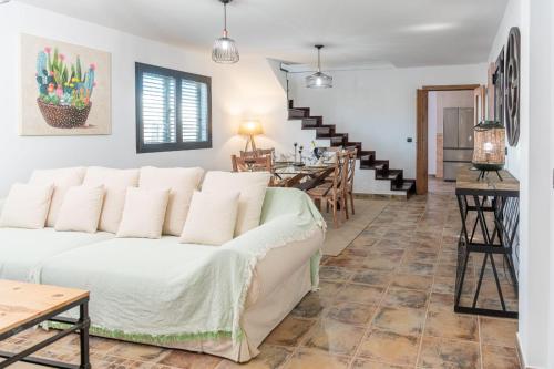 a living room with a white couch and a table at Villa Alejandra in Lajares