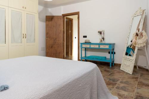 a bedroom with a bed and a blue table at Villa Alejandra in Lajares