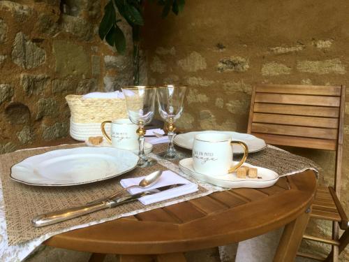 une table en bois avec des assiettes et des verres dans l'établissement Chambre d'hôtes, les Sentiers de l'Awen, à Louerre